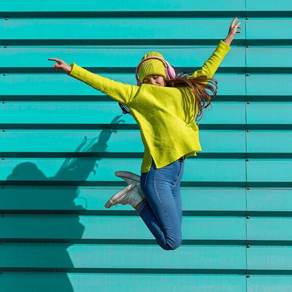 Latinx high school girl jumping in air - Connections Academy